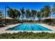 Community lap pool surrounded by mature landscaping with shade, tables and lounge chairs at 3240 Avernus Ave, Henderson, NV 89044