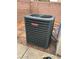 An outdoor Goodman AC unit, sitting on red bricks in front of a tan brick wall at 3936 Pepper Thorn Ave # 102, North Las Vegas, NV 89081