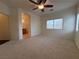 Spacious carpeted bedroom featuring a ceiling fan, dual windows, and an attached bathroom at 3936 Pepper Thorn Ave # 102, North Las Vegas, NV 89081
