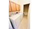 Laundry room with tile flooring, wooden cabinets and a stackable washer and dryer at 3936 Pepper Thorn Ave # 102, North Las Vegas, NV 89081