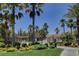 Community pool surrounded by lush green landscaping, palm trees, and wrought iron fencing at 3936 Pepper Thorn Ave # 102, North Las Vegas, NV 89081