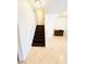 Staircase with dark wood steps and white railing with light colored tile on the first floor entry at 3936 Pepper Thorn Ave # 102, North Las Vegas, NV 89081