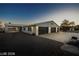 Three car attached garage and covered patio, a white brick home with black doors and black shutters at 3950 Oakridge Ave, Pahrump, NV 89048