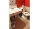 Bathroom features a toilet, sink, red wall, and tiled flooring at 4119 Meadowglen Cir, Las Vegas, NV 89121