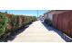 Long driveway leading to property with landscaped hedges and partial backyard fencing at 4119 Meadowglen Cir, Las Vegas, NV 89121