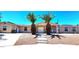 Close-up of a house featuring xeriscaping, concrete steps, and a double-door entrance framed by palm trees at 4119 Meadowglen Cir, Las Vegas, NV 89121