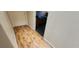 Hallway with wood-look floors leading to a door and view of a bedroom at 4119 Meadowglen Cir, Las Vegas, NV 89121
