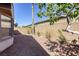 A low-maintenance backyard featuring gravel, a block wall, mature trees, and a window view at 4124 Gliding Gulls Ave, North Las Vegas, NV 89084