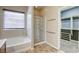 Bright bathroom featuring a soaking tub, glass-enclosed shower, and walk-in closet at 4124 Gliding Gulls Ave, North Las Vegas, NV 89084