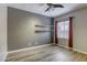 Stylish bedroom featuring wood-look flooring, modern wall shelves, and large window with decorative curtains at 4124 Gliding Gulls Ave, North Las Vegas, NV 89084