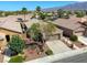 Home's front yard with desert landscaping, a two-car garage, palm trees, and mature desert trees at 4124 Gliding Gulls Ave, North Las Vegas, NV 89084