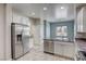 Well-lit kitchen features stainless steel appliances, granite countertops, and tile flooring at 4124 Gliding Gulls Ave, North Las Vegas, NV 89084