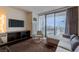 Inviting living room with plush seating, city views, and sleek, dark wood floors at 4381 W Flamingo Rd # 3818, Las Vegas, NV 89103