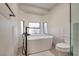 Bright bathroom featuring a soaking tub, tile flooring, and modern fixtures at 5242 Dickens Dr, Las Vegas, NV 89119