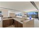 Kitchen bar with quartz countertop, seating, cabinetry, and adjacent seating area with mountain views at 53 Falling Ridge Ln, Henderson, NV 89011
