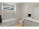 Well-lit bathroom featuring a soaking tub, a modern toilet, and a sleek vanity with a large mirror at 53 Falling Ridge Ln, Henderson, NV 89011