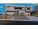 Striking modern home with clean lines, a spacious driveway, manicured landscaping, and elegant exterior lighting at 53 Falling Ridge Ln, Henderson, NV 89011