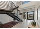 Modern foyer boasts sleek staircase, neutral tones, and abundant natural light at 53 Falling Ridge Ln, Henderson, NV 89011