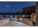 Relaxing outdoor spa area with hot tub, built-in grill, and picturesque mountain views under the moonlight at 53 Falling Ridge Ln, Henderson, NV 89011
