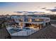 An amazing rear exterior with a modern design including a pool, outdoor seating and views of mountains and city lights at 53 Falling Ridge Ln, Henderson, NV 89011