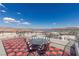 Rooftop deck with a table, chairs and panoramic views of a lake and mountains under a clear blue sky at 53 Falling Ridge Ln, Henderson, NV 89011
