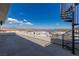 Rooftop deck with a spiral staircase and panoramic views of a lake and mountains under a clear blue sky at 53 Falling Ridge Ln, Henderson, NV 89011