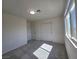 Bright bedroom featuring carpeted floors, a window, and closet doors at 5817 Bonita Rose St, Las Vegas, NV 89113