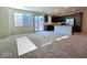 Open-concept living room featuring plush carpeting, large windows, and a breakfast bar adjoining a modern kitchen at 5817 Bonita Rose St, Las Vegas, NV 89113