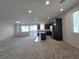 Open-concept living room and kitchen with stainless steel appliances and gray cabinets at 5817 Bonita Rose St, Las Vegas, NV 89113