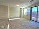 Bright living room with neutral walls, large windows, and sliding glass doors leading to outdoor space at 5817 Bonita Rose St, Las Vegas, NV 89113