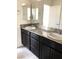 Well-lit bathroom with dual sinks, dark cabinetry, and granite countertops at 6168 Scarlet Leaf St, Las Vegas, NV 89148