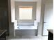 Bathroom with a soaking tub, white tile surround, and neutral walls at 6168 Scarlet Leaf St, Las Vegas, NV 89148