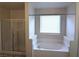 Modern bathroom with separate glass shower and soaking tub surrounded by bright white walls at 6168 Scarlet Leaf St, Las Vegas, NV 89148