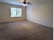 Large bedroom with plush carpet, neutral walls, and a bright window showing neighborhood views at 6168 Scarlet Leaf St, Las Vegas, NV 89148