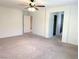 Spacious bedroom with neutral walls, carpeted floors, ceiling fan, and access to ensuite bathroom and closet at 6168 Scarlet Leaf St, Las Vegas, NV 89148
