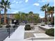 Community pool featuring multiple palm trees, nearby picnic tables, and access ramps and landscaping at 6168 Scarlet Leaf St, Las Vegas, NV 89148