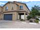 Two-story home featuring a blue garage door, gated entry, and low maintenance desert landscaping at 6168 Scarlet Leaf St, Las Vegas, NV 89148