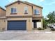 Two-story home features a blue garage door and a charming, gated entryway at 6168 Scarlet Leaf St, Las Vegas, NV 89148