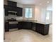Dark wood cabinets, stainless appliances, and granite counters are the highlights of this stylish kitchen at 6168 Scarlet Leaf St, Las Vegas, NV 89148