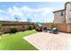 Charming backyard featuring a brick patio, artificial grass, and a cute playhouse with outdoor seating at 6650 Drusilla St, North Las Vegas, NV 89084