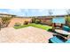 Charming backyard featuring a brick patio, artificial grass, garden area, and a cute playhouse at 6650 Drusilla St, North Las Vegas, NV 89084