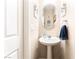 A half bath with a pedestal sink, a decorative mirror, and light neutral paint at 6650 Drusilla St, North Las Vegas, NV 89084