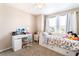 Bright bedroom featuring a day bed with floral comforter and a white desk at 6650 Drusilla St, North Las Vegas, NV 89084