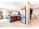 A wide shot of kitchen leading to dining area with stainless fridge and tile flooring at 6650 Drusilla St, North Las Vegas, NV 89084