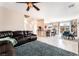 Spacious living room featuring a plush couch, tile floors, and a ceiling fan at 6650 Drusilla St, North Las Vegas, NV 89084