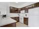 Efficient kitchen with white countertops, white appliances, dark cabinets, and a tiled floor at 7119 S Durango Dr # 303, Las Vegas, NV 89113