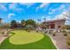 Expansive backyard showcasing a putting green and a covered outdoor seating area, perfect for entertaining at 7470 Eldora Av, Las Vegas, NV 89117
