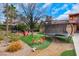 A unique backyard features a colorful playground, built-in trampoline and lovely trees at 7470 Eldora Av, Las Vegas, NV 89117