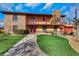 Two-story home with stone facade, red trim, a balcony, and well-manicured lawn at 7470 Eldora Av, Las Vegas, NV 89117