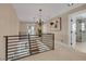 Upstairs hallway with iron railing and chandelier offers views of staircase and an adjacent bathroom at 7470 Eldora Av, Las Vegas, NV 89117
